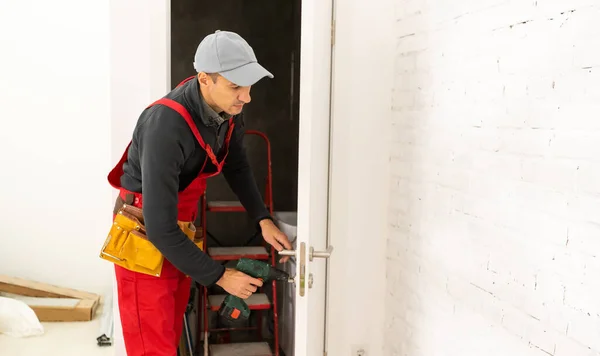 Man fixing locks with screwdriver in a new house — Stock Photo, Image