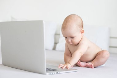 Beyaz arka planda dizüstü bilgisayarı olan bebek.