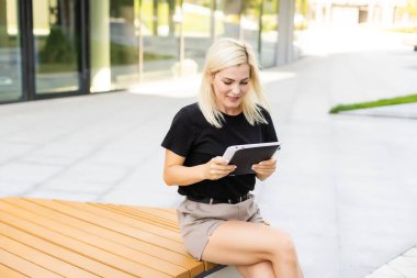 Dijital tablet ile mutlu bir genç kadın.