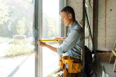 İnşaat işçisi eve pencere kuruyor