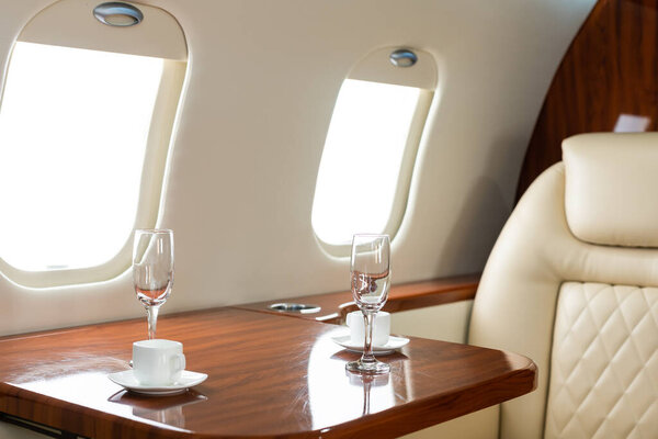 Cabin of luxury private jet. Empty aircraft with white leather chairs.