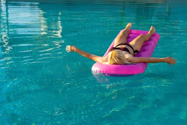 Jeune jolie femme sur matelas gonflable dans la piscine — Photo