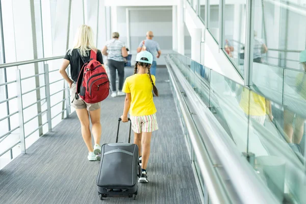 Mãe e filha vão com malas para o aeroporto. turismo e viagens. — Fotografia de Stock