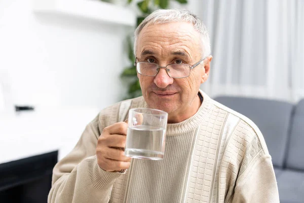 Male senior citizen in shirt drinking water — Stock Photo, Image