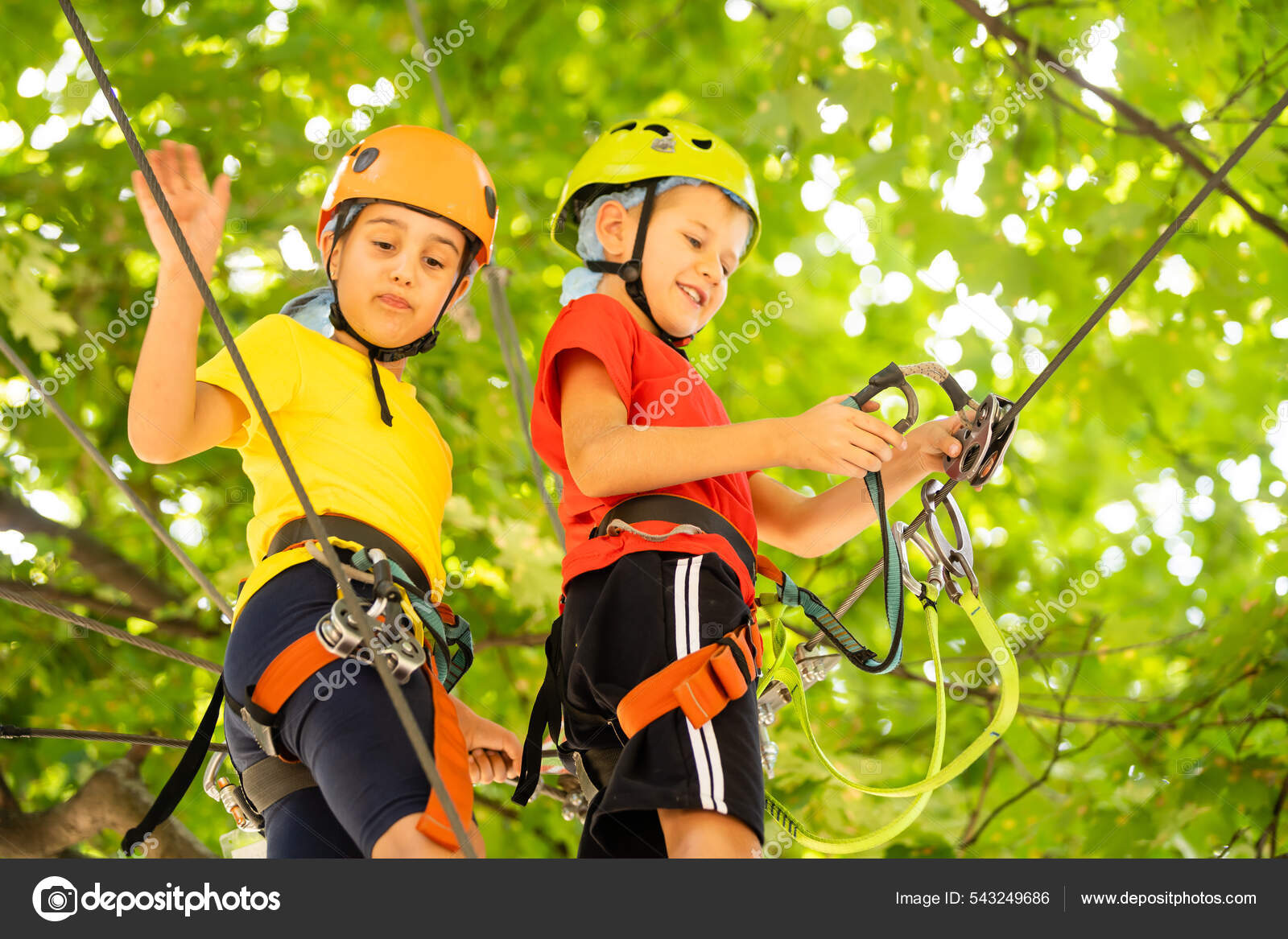 Child in forest adventure Kids climb on high rope trail