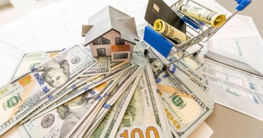 İnşaat planları, hesap makinesi, para ve kulübenin planı. Kendi evini geçindirmenin bedeli. Mülkün fiyatı. İpotek kredisi. Emlak kredisinin teminatı.