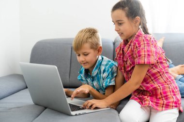 evde dizüstü bilgisayar ile oynayan çocuklar