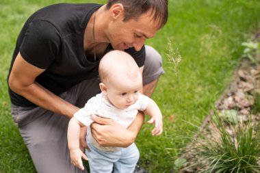 Babası ve oğlu yaz parkında yürüyor.