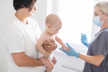 Şırıngalı, gergin anne ve bebeği olan çocuk doktoru.