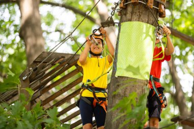 Ağaçlara tırmanan mutlu çocuk. Halat Parkı. Climber çocuğu. Erken çocukluk gelişimi. Roping Parkı. Denge kiriş ve halat köprüler. Halat Park-tırmanış merkezi