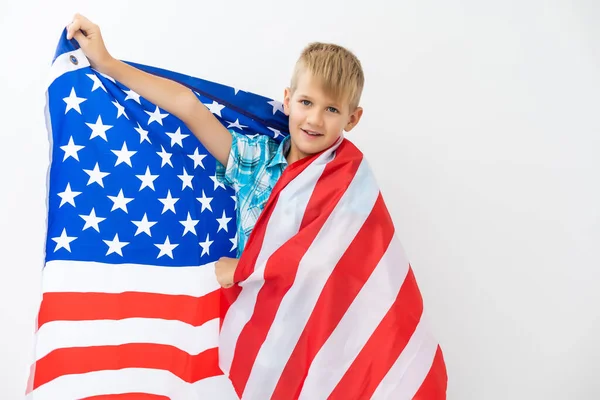 금발의 소년, 야외에서 흰색 배경으로 미국 국기를 흔들고 있습니다. 미국 국기, 애국심, 독립일 4 일째 공정 한 개념 — 스톡 사진