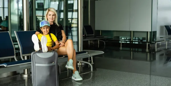 Maskeli bir anne havaalanında uçmayı bekliyor. Uluslararası havaalanında küçük kızı olan bir kadın.. — Stok fotoğraf