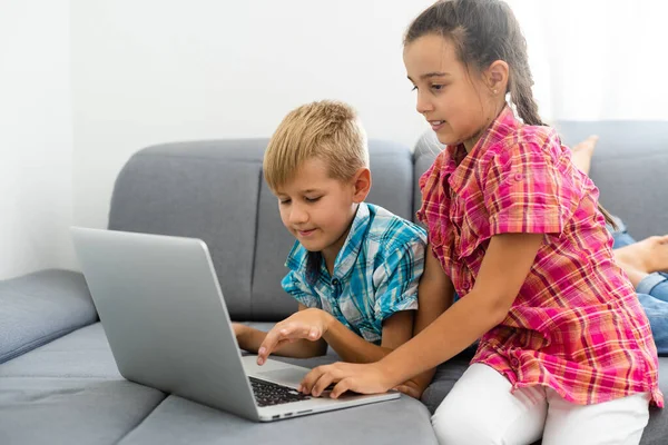 Дети играют с ноутбуком дома — стоковое фото