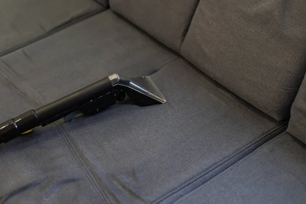 Limpeza das mãos um sofá com um aspirador de vapor, conceito de limpeza em casa — Fotografia de Stock