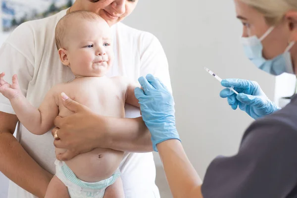Médico pediatra con jeringa, madre tensa y bebé — Foto de Stock