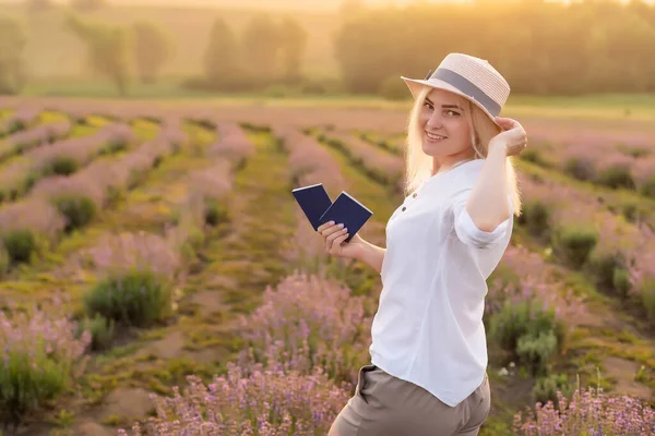 Młoda blondynka kobieta podróżnik noszenie słomy kapelusz w lawendy pole otoczone lawendy kwiaty. — Zdjęcie stockowe