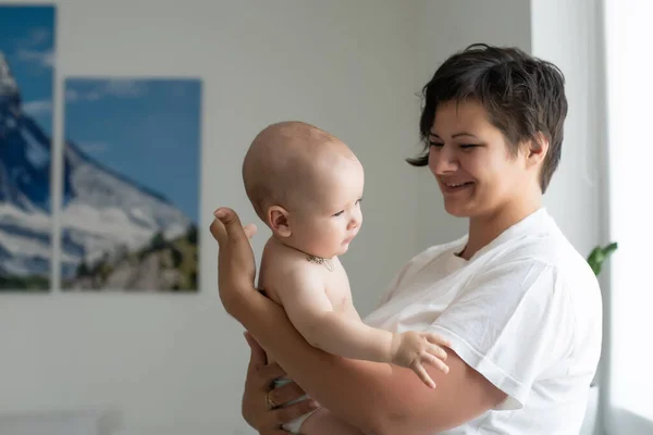 Μητέρα που κρατά το μωρό σε λευκό υπνοδωμάτιο — Φωτογραφία Αρχείου