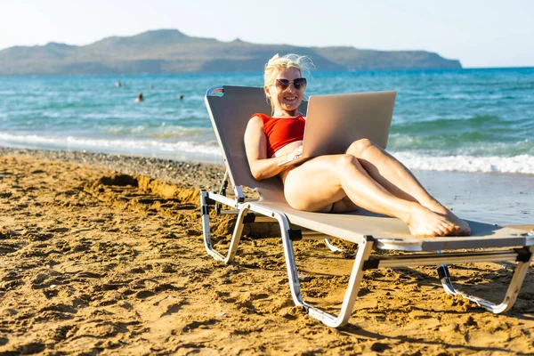 Mulher usando laptop na praia — Fotografia de Stock