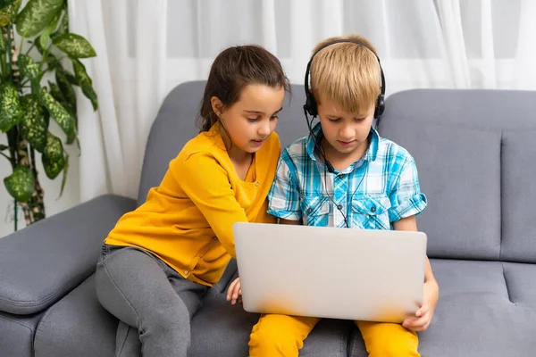 Bambini che giocano con il computer portatile a casa — Foto Stock