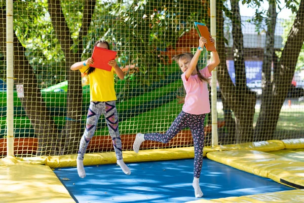 Duas meninas pulando em um trampolim em um dia de verão. — Fotografia de Stock