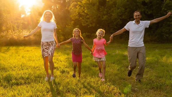 Boldog család apja anya és a gyerekek a természetben naplementekor — Stock Fotó