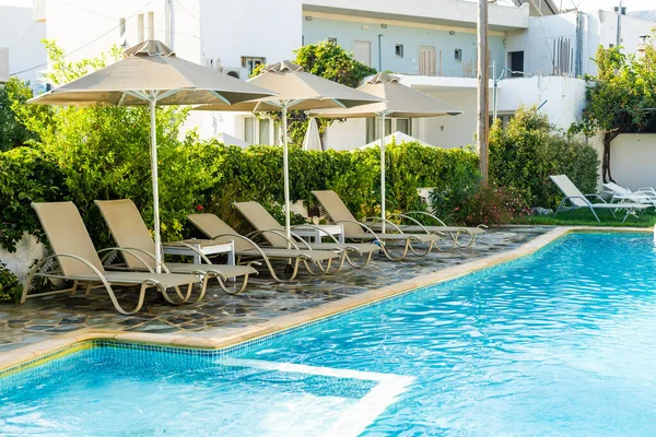 Tumbonas al lado de una piscina. — Foto de Stock