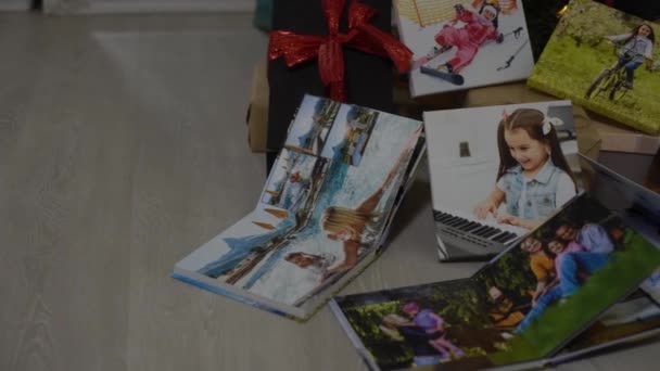 새해 나무 근처에 있는 사진들, 휴일 선물로 색깔 이 있는 책들. — 비디오