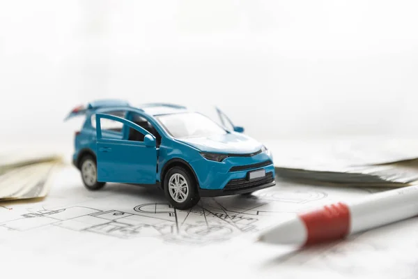 Klein speelgoed auto en houten speelgoed huis close-up afbeelding op blauwdruk achtergrond. — Stockfoto