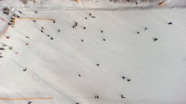 Kayak merkezindeki yamaçta İHA görüntüsü. Orman ve kayak pisti havadan. İnsansız hava aracının kış manzarası. Kayak merkezindeki karlı manzara. Hava fotoğrafçılığı