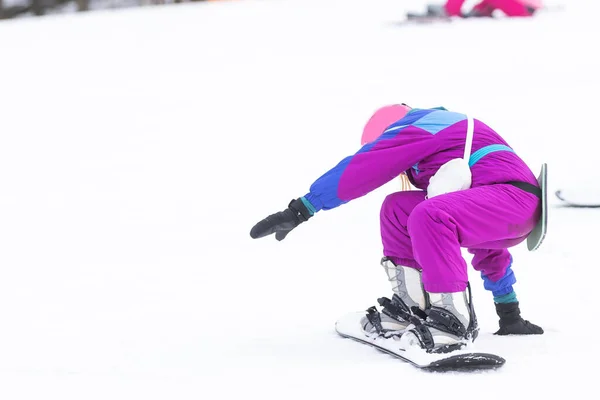 Pequena menina bonito aprender a montar um snowboard crianças, esportes de inverno para a criança, segurança de esportes ativos. — Fotografia de Stock