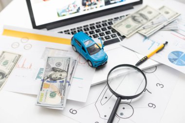 Çarşaf çizimleri üzerinde para ve oyuncak araba modeli