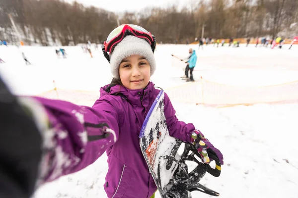 Μικρό χαριτωμένο κορίτσι μαθαίνουν να οδηγούν μια παιδική snowboard, χειμερινά σπορ για το παιδί, την ασφάλεια των ενεργών αθλητικών. — Φωτογραφία Αρχείου