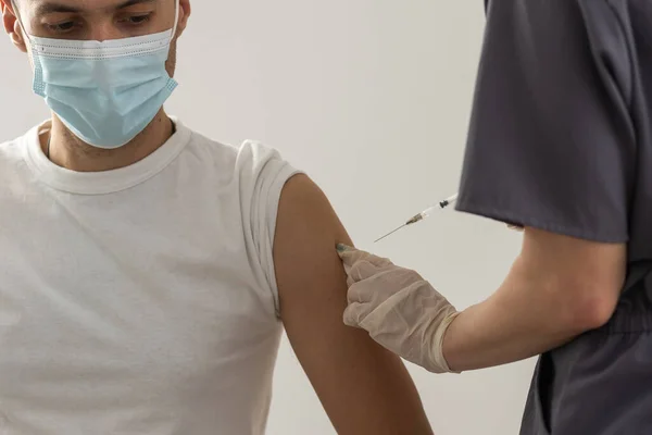 L'injection du vaccin COVID-19, le médecin en gants tient la seringue et fait du jab à la patiente en clinique. Prévention du coronavirus ou de la grippe. virus corona et vaccin antigrippal, thérapie et traitement. — Photo