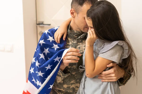 Uma menina abraça um pai militar. O pai de uniforme militar com a filha. os veteranos voltam para a família — Fotografia de Stock
