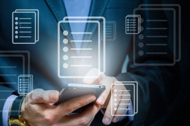 Bir programcı, bir siber güvenliği hacker saldırılarından korumak ve müşterilerinin gizli verilerini kaydetmek için akıllı telefonuyla internete giriyor. Yazan ellerin üzerine hologram simgeleri.