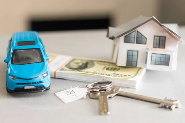 Ahorro de dinero coche de juguete pequeño con el concepto de préstamo de la casa de crecimiento financiero y la propiedad en la mesa de fondo gris —  Fotos de Stock