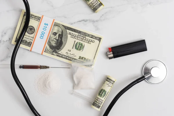 Vysoké náklady na nákladné léky koncept, peníze a stetoskop. — Stock fotografie