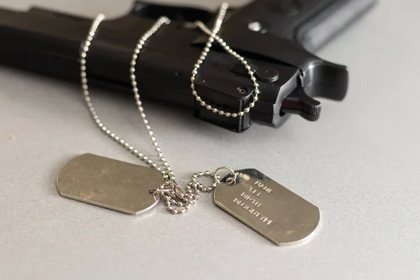 Gun and dogtag isolated on a white background — Stock Photo, Image