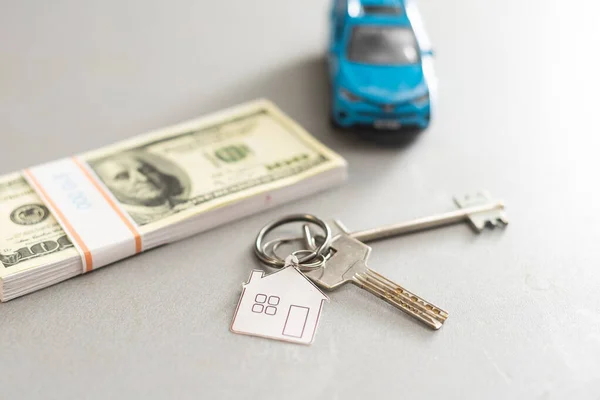 Coche azul del juguete con el dinero y la llave del coche en la mesa de madera . —  Fotos de Stock