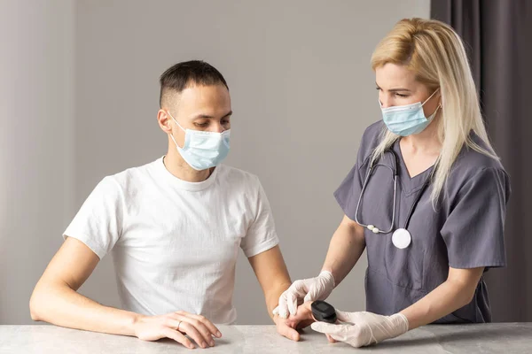 Arzt überprüft Sauerstoffversorgung mit Fingerspitzenpulsoximeter. Sättigungsblut des Sauerstoffs — Stockfoto