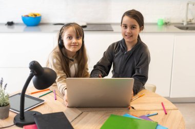 Bağlantı iyi. Seni duyabiliyorum. Küçük kız rahat masa başı çalışma uzaktan bilgisayarla internet üzerinden öğretmenlerle iletişim kurma ev içinde kulaklık var..