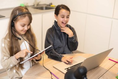 Liseli kız, evdeki oturma odasında dizüstü bilgisayarında öğretmeniyle video konferansı yapıyor. Evde eğitim, uzaktan öğrenme, koronavirüs salgınına bağlı online eğitim. Yan görüş. E-öğrenme kavramı