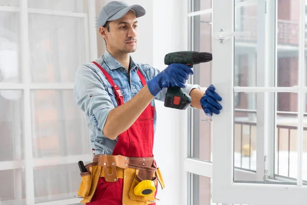 O trabalhador instalando e verificando janela na casa — Fotografia de Stock