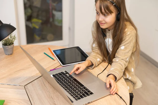 Educación en línea de los niños. Chica colegiala tiene una lección en línea utilizando un ordenador portátil de chat de vídeo llamada de conferencia con un profesor en casa. — Foto de Stock