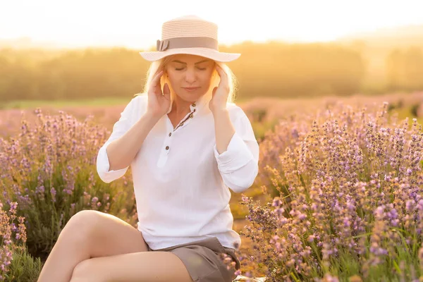 Lavanta tarlasında duran genç bir kadın ve arka planda gün doğumu.