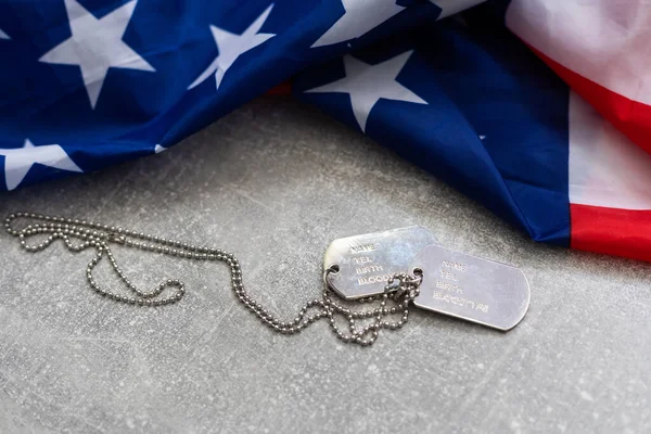 Authentic military dog tag on an american flag — Stock Photo, Image