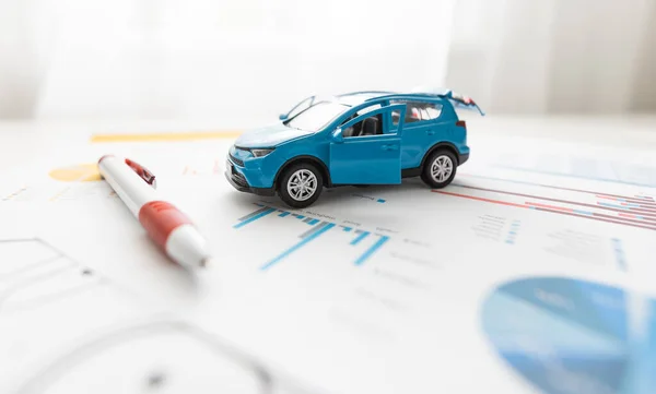 Vooraanzicht van een blauwe speelgoedauto op vellen tekeningen — Stockfoto