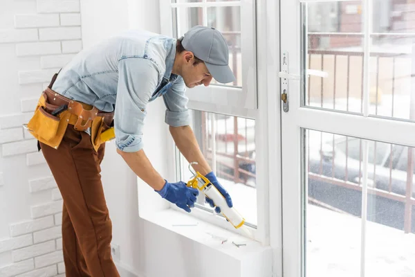 Handsome young man installing bay window in a new house construction site. — Stock Photo, Image