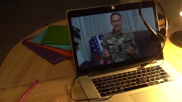 Brunetka żołnierz człowiek macha ręką podczas rozmowy konferencyjnej na laptopie wewnątrz. — Wideo stockowe