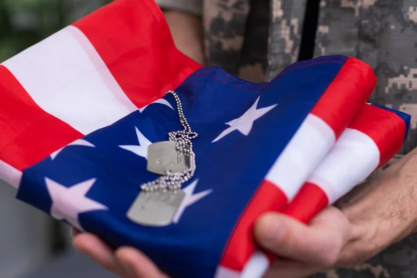 Amerikai katona áll szemben a fehér háttér egy zászlót. A veteránok emléknapjának koncepciója. — Stock Fotó